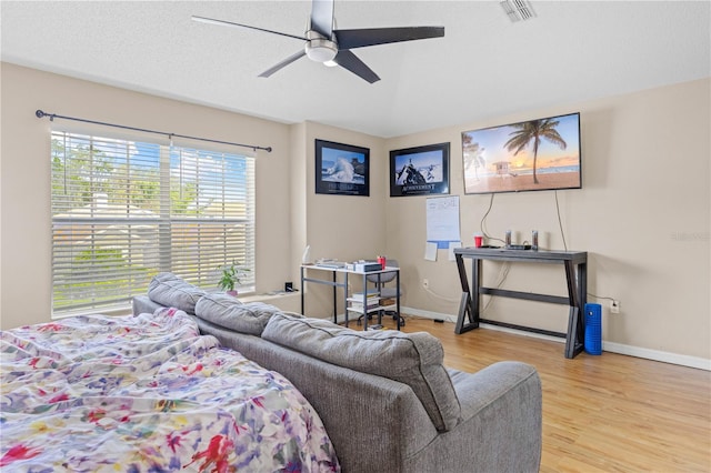 bedroom featuring ceiling fan, light hardwood / wood-style floors, and a textured ceiling