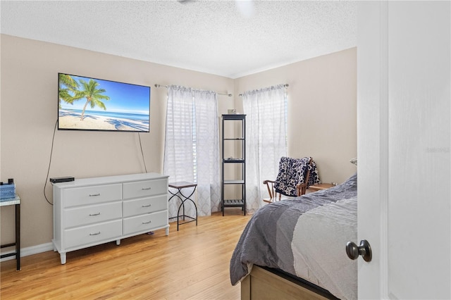 bedroom featuring light hardwood / wood-style floors and a textured ceiling