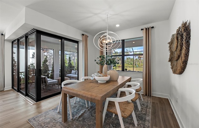 dining room with plenty of natural light, a notable chandelier, and hardwood / wood-style flooring