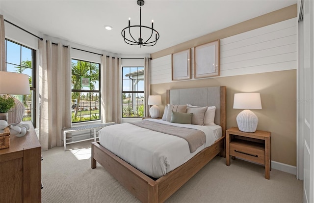 bedroom featuring a notable chandelier, light colored carpet, and multiple windows