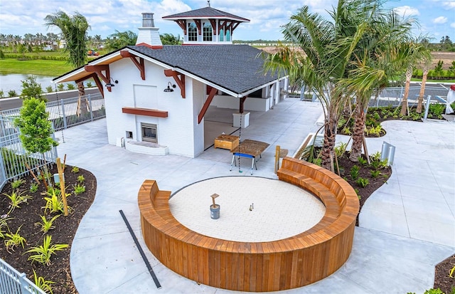 view of front facade with a patio area and exterior fireplace