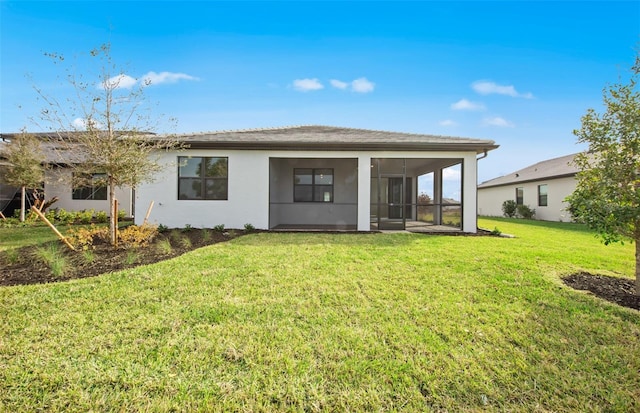 rear view of property featuring a sunroom and a lawn