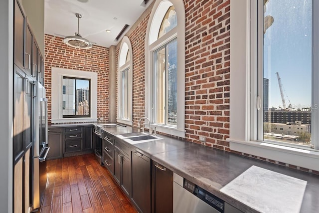 405 Central Ave Unit 700, Saint Petersburg, FL 33701 - kitchen with a sink, brick wall, dark wood finished floors, pendant lighting, and dark brown cabinets