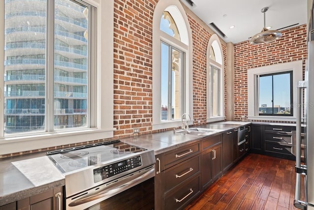 kitchen featuring brick wall, a healthy amount of sunlight, and stainless steel range oven