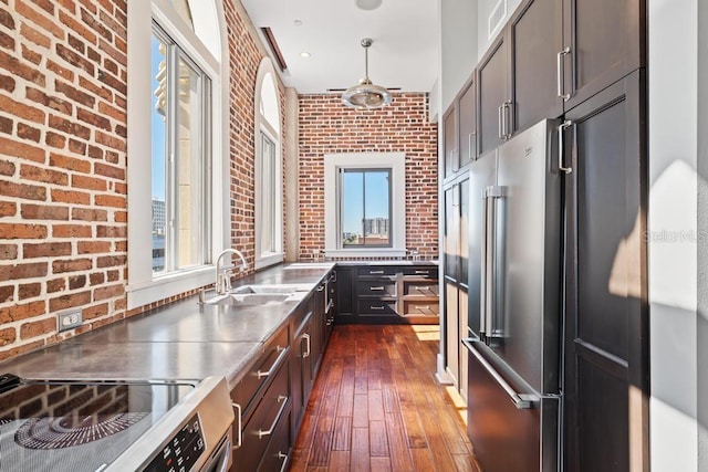 405 Central Ave Unit 700, Saint Petersburg, FL 33701 - kitchen featuring stainless steel counters, a sink, stainless steel appliances, dark wood-style flooring, and brick wall