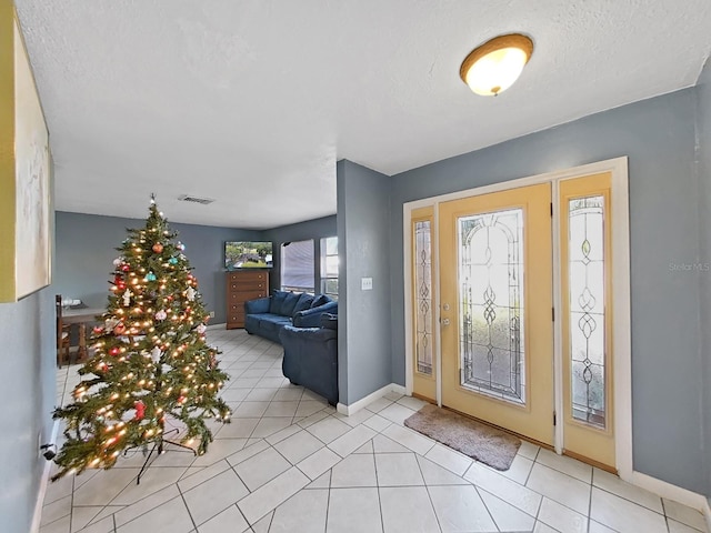 entrance foyer with a textured ceiling and light tile patterned flooring