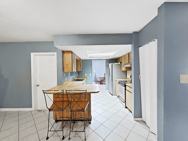 kitchen with white appliances, ventilation hood, sink, kitchen peninsula, and a breakfast bar area