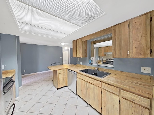 kitchen with light tile patterned floors, kitchen peninsula, sink, and appliances with stainless steel finishes