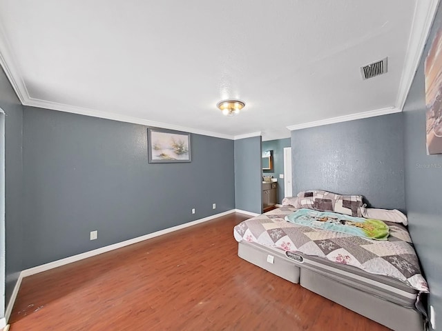 bedroom with hardwood / wood-style floors and crown molding