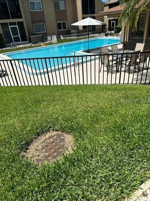 view of swimming pool with a lawn