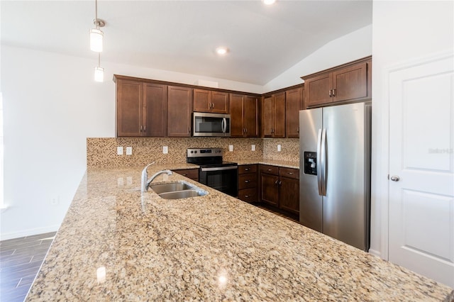 kitchen featuring decorative backsplash, stainless steel appliances, sink, pendant lighting, and lofted ceiling