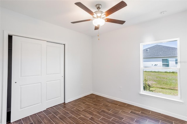 unfurnished bedroom featuring ceiling fan, dark hardwood / wood-style flooring, and a closet