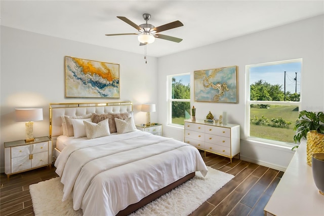 bedroom with ceiling fan, dark hardwood / wood-style flooring, and multiple windows