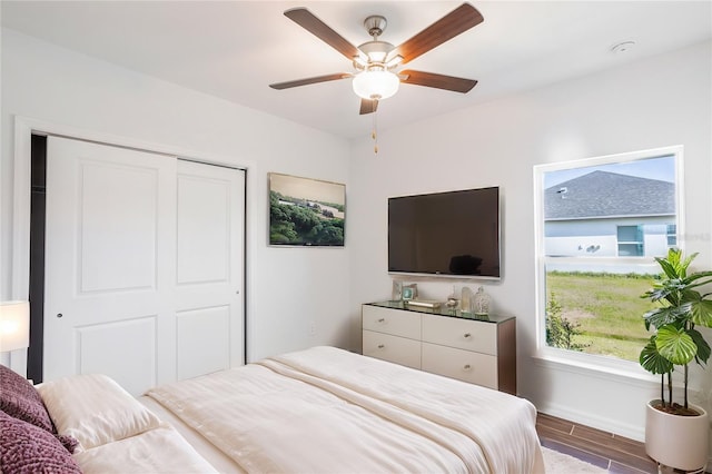 bedroom with hardwood / wood-style floors, ceiling fan, and a closet