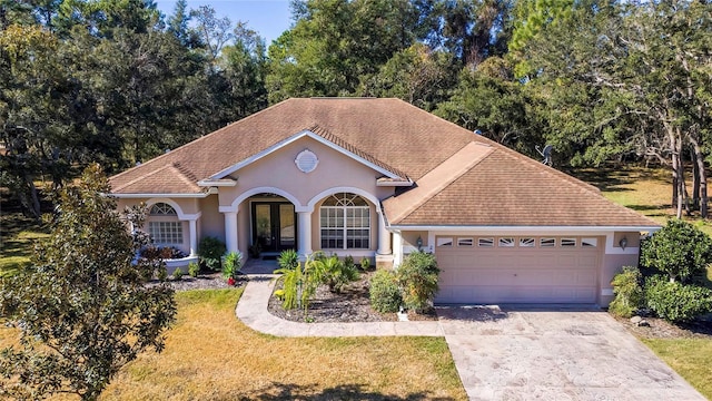 view of front of house featuring french doors, a garage, and a front lawn