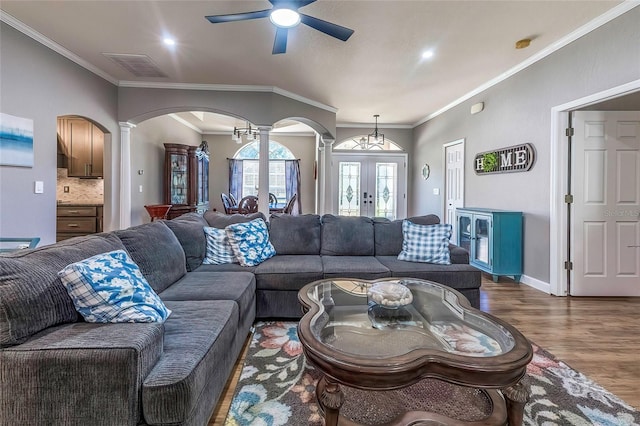 living room featuring french doors, ornate columns, ceiling fan, dark wood-type flooring, and crown molding