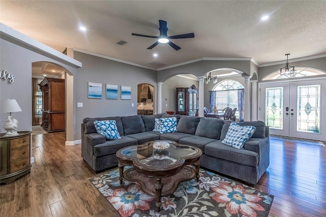 living room featuring ornate columns, ceiling fan, dark wood-type flooring, a textured ceiling, and ornamental molding