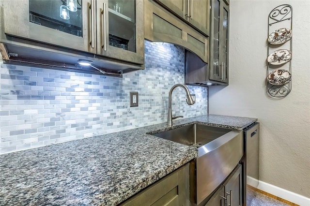 kitchen with decorative backsplash, sink, and dark stone counters