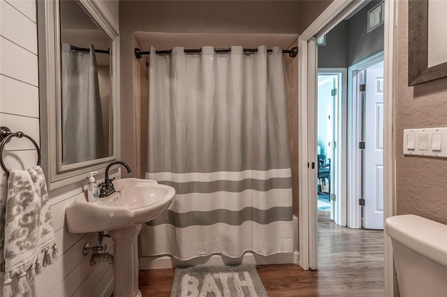 bathroom with hardwood / wood-style flooring and toilet