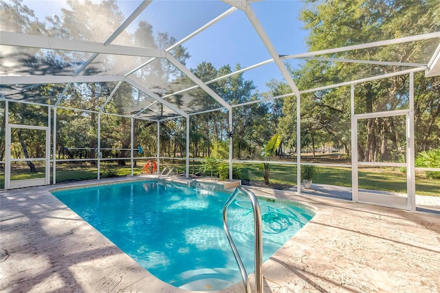 view of swimming pool featuring glass enclosure and a patio area