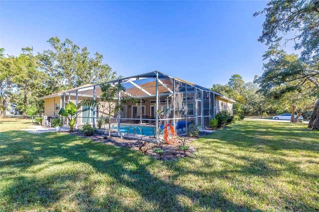 rear view of house with a lanai and a lawn