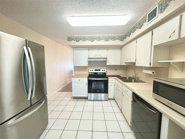 kitchen featuring white cabinets, sink, stainless steel appliances, and a textured ceiling