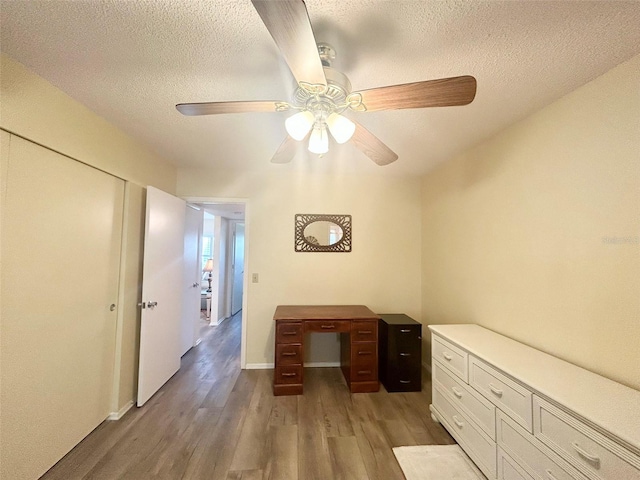 unfurnished office with ceiling fan, a textured ceiling, and light hardwood / wood-style flooring