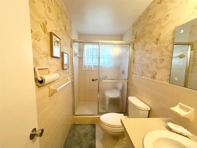 bathroom featuring vanity, tile patterned flooring, toilet, tile walls, and walk in shower