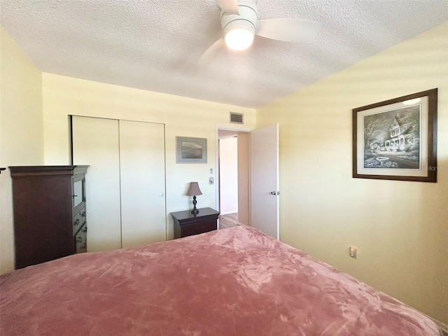 unfurnished bedroom with ceiling fan, a textured ceiling, and a closet