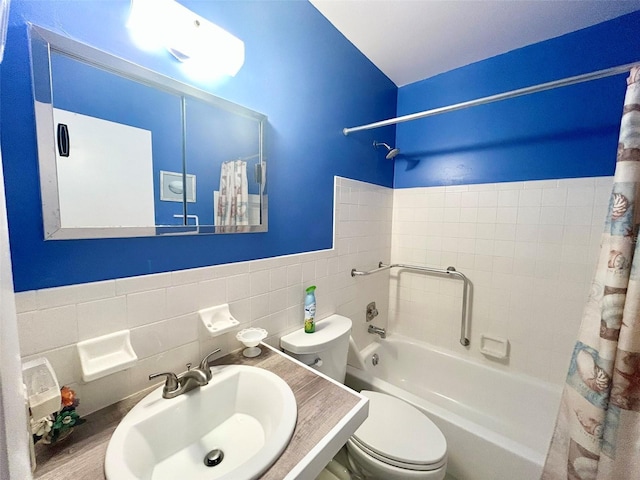 full bath with shower / bath combination with curtain, a sink, tile walls, and toilet