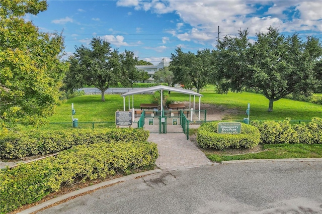 view of home's community with a yard, a gate, and fence