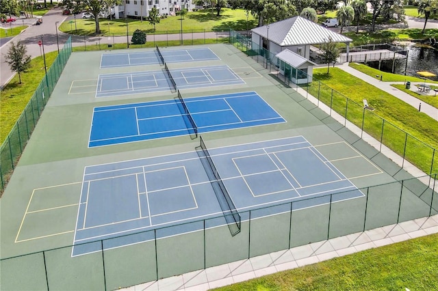 view of sport court featuring fence and a lawn