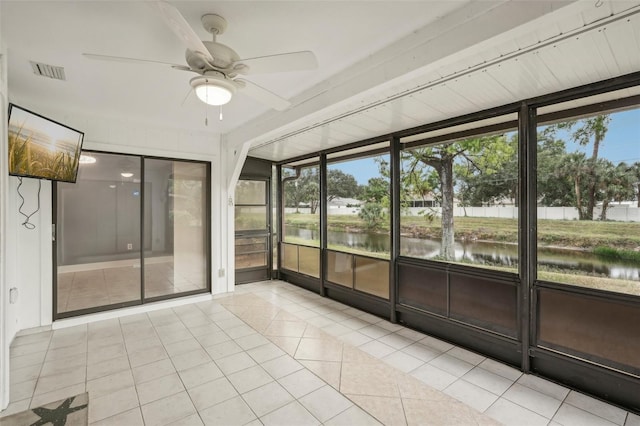 unfurnished sunroom with ceiling fan and a water view