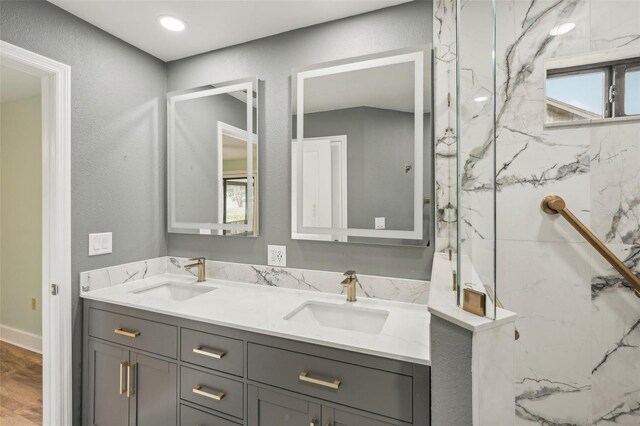 bathroom featuring a tile shower and vanity