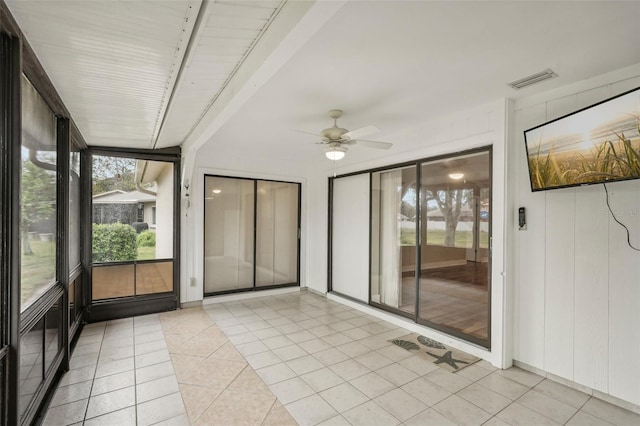 unfurnished sunroom featuring ceiling fan