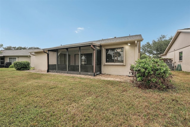 rear view of house featuring a sunroom, cooling unit, and a lawn