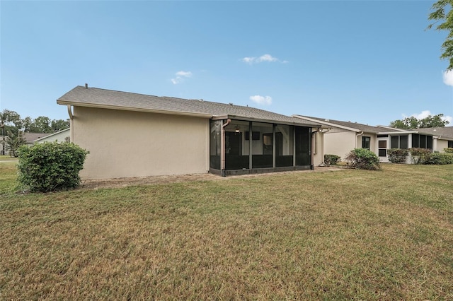 rear view of property with a yard and a sunroom