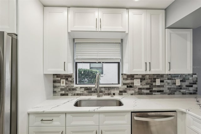 kitchen featuring white cabinets, sink, light stone countertops, and stainless steel appliances