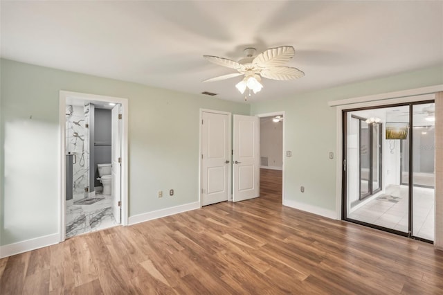 unfurnished bedroom featuring wood-type flooring, ensuite bathroom, and ceiling fan