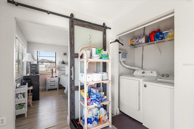 laundry room with a barn door, washer and dryer, and dark hardwood / wood-style floors