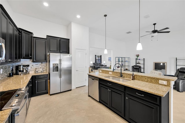 kitchen featuring ceiling fan, sink, hanging light fixtures, a center island with sink, and appliances with stainless steel finishes