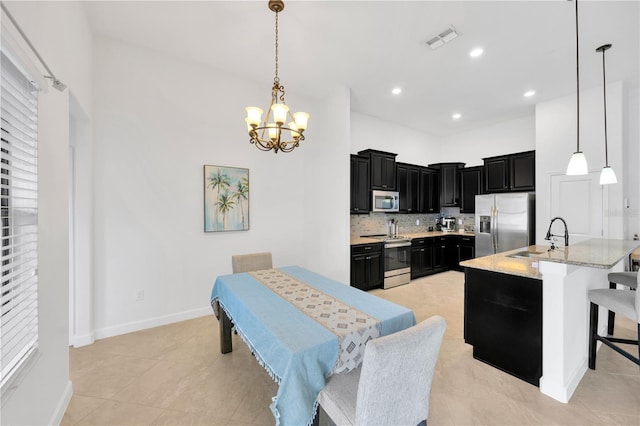 tiled dining space featuring sink and a notable chandelier