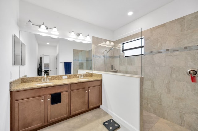 bathroom with a tile shower, tile patterned floors, and vanity