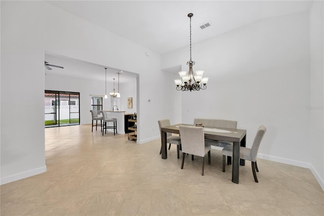 dining space featuring light tile patterned floors and ceiling fan with notable chandelier