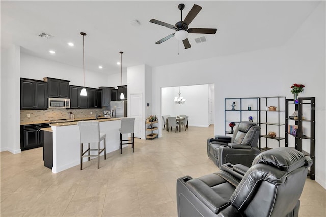 living room with ceiling fan with notable chandelier and light tile patterned floors