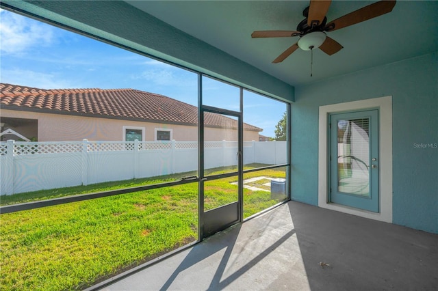 unfurnished sunroom with ceiling fan