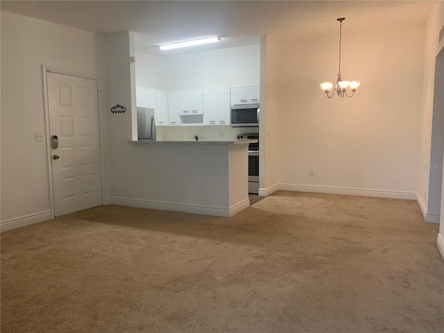 interior space featuring pendant lighting, white cabinets, kitchen peninsula, stainless steel appliances, and a chandelier