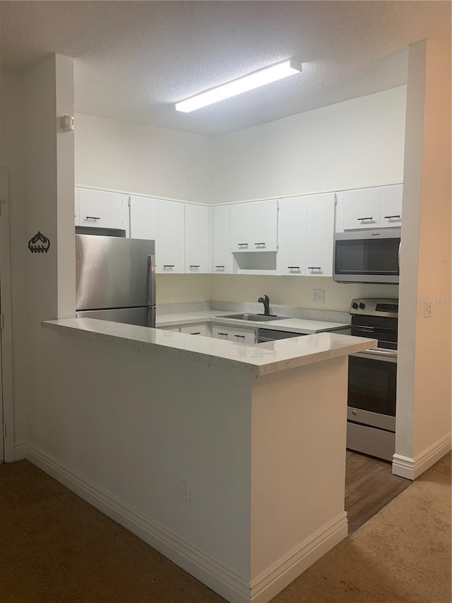 kitchen with white cabinets, kitchen peninsula, and stainless steel appliances