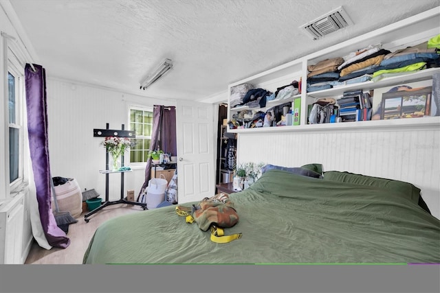 bedroom with light wood-type flooring and a textured ceiling