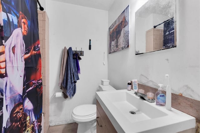 bathroom with a shower with shower curtain, vanity, and toilet